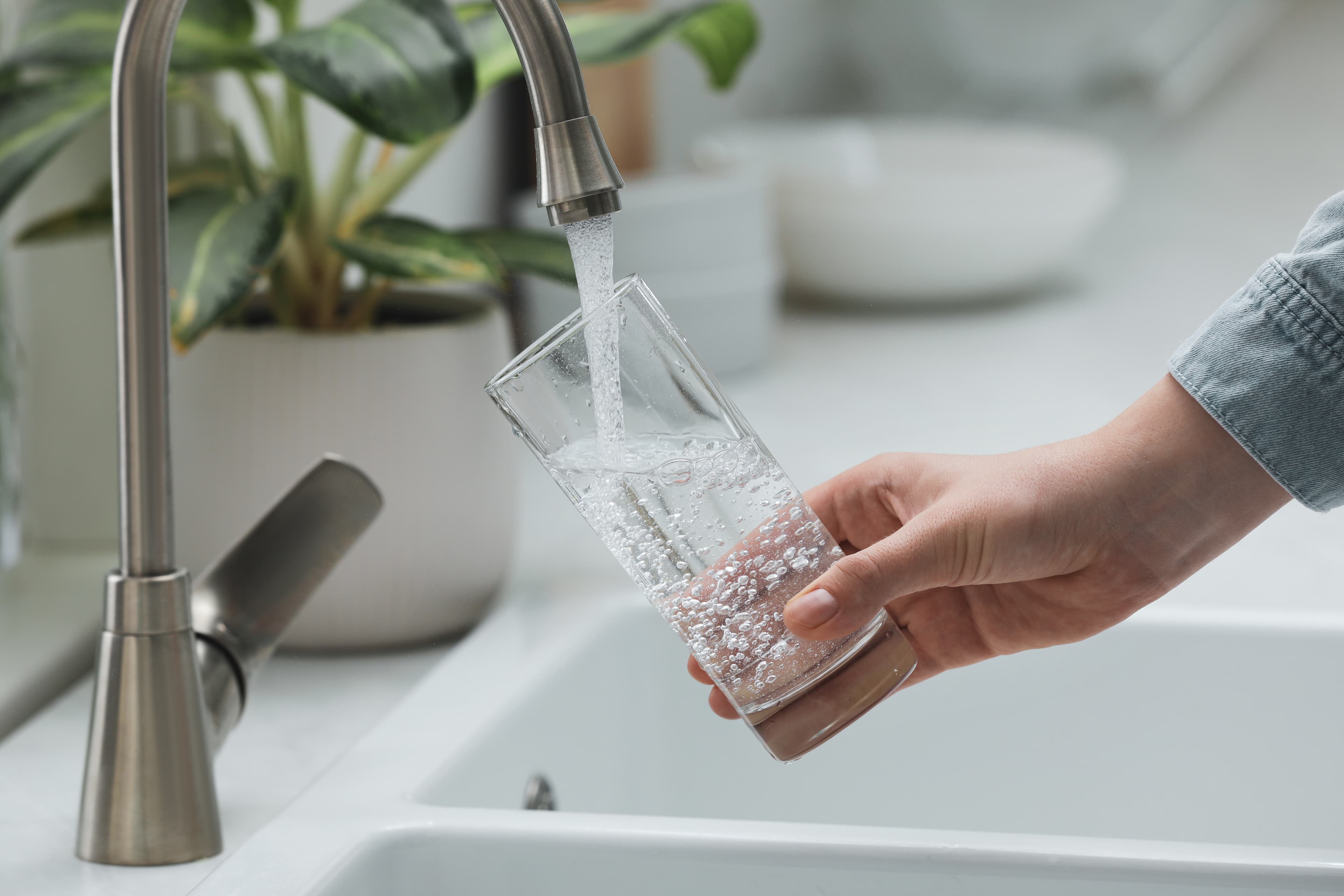 Crystal clear purified water being filled from tap