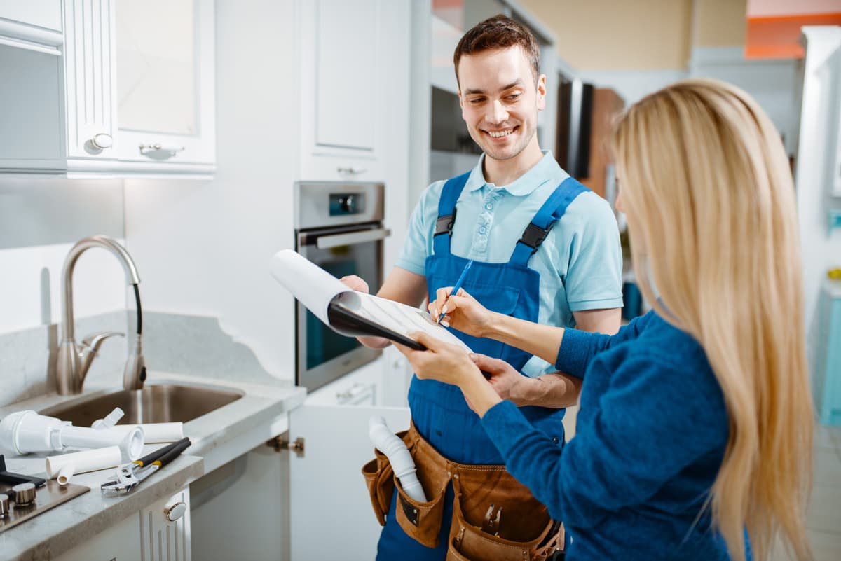 Water treatment technician consulting with homeowner in kitchen